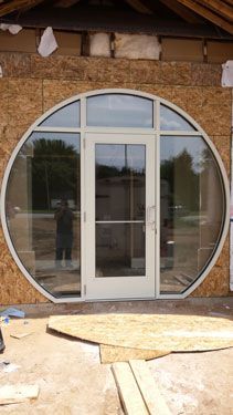 A white door with a round window on the side of a building.