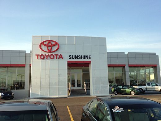 A toyota dealership with cars parked in front of it