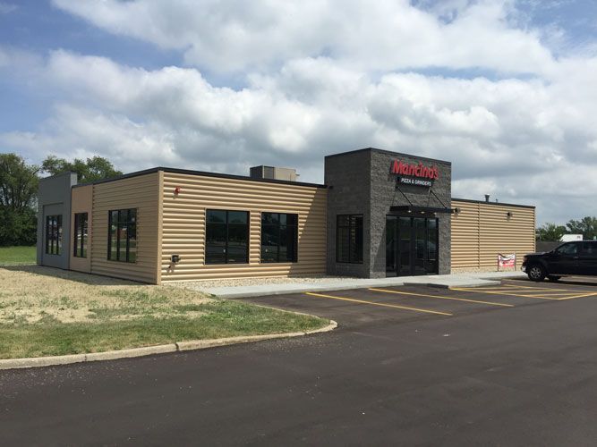 A large building with a lot of windows and a truck parked in front of it.