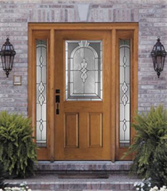 The front door of a brick house has a stained glass window