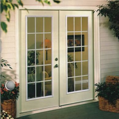 A white door with a lot of windows is open to a living room