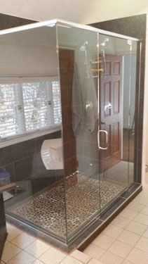 A bathroom with a walk in shower with sliding glass doors.