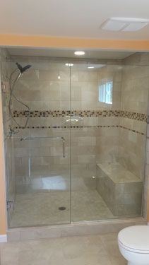 A bathroom with a walk in shower and a toilet.