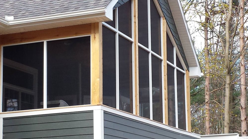 Screened porch with gray siding, white trim, and a gabled roof.