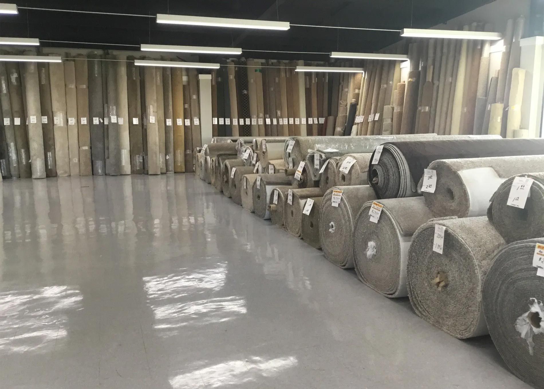 a large warehouse filled with lots of rolls of carpet .