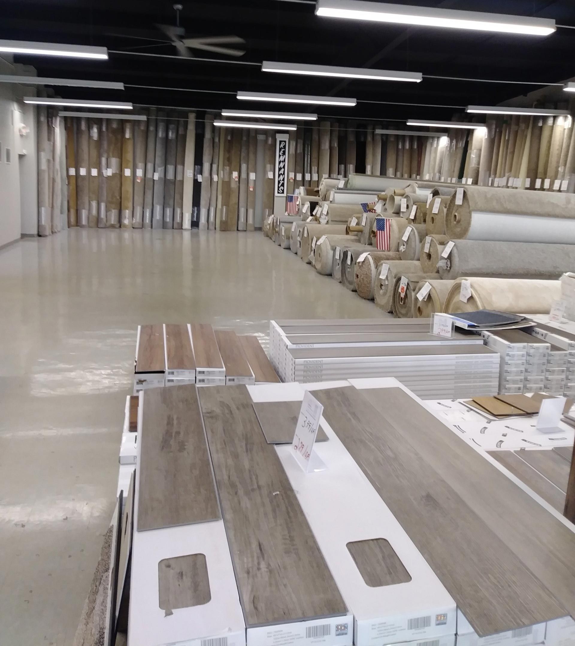 a warehouse filled with lots of boxes and rolls of carpet