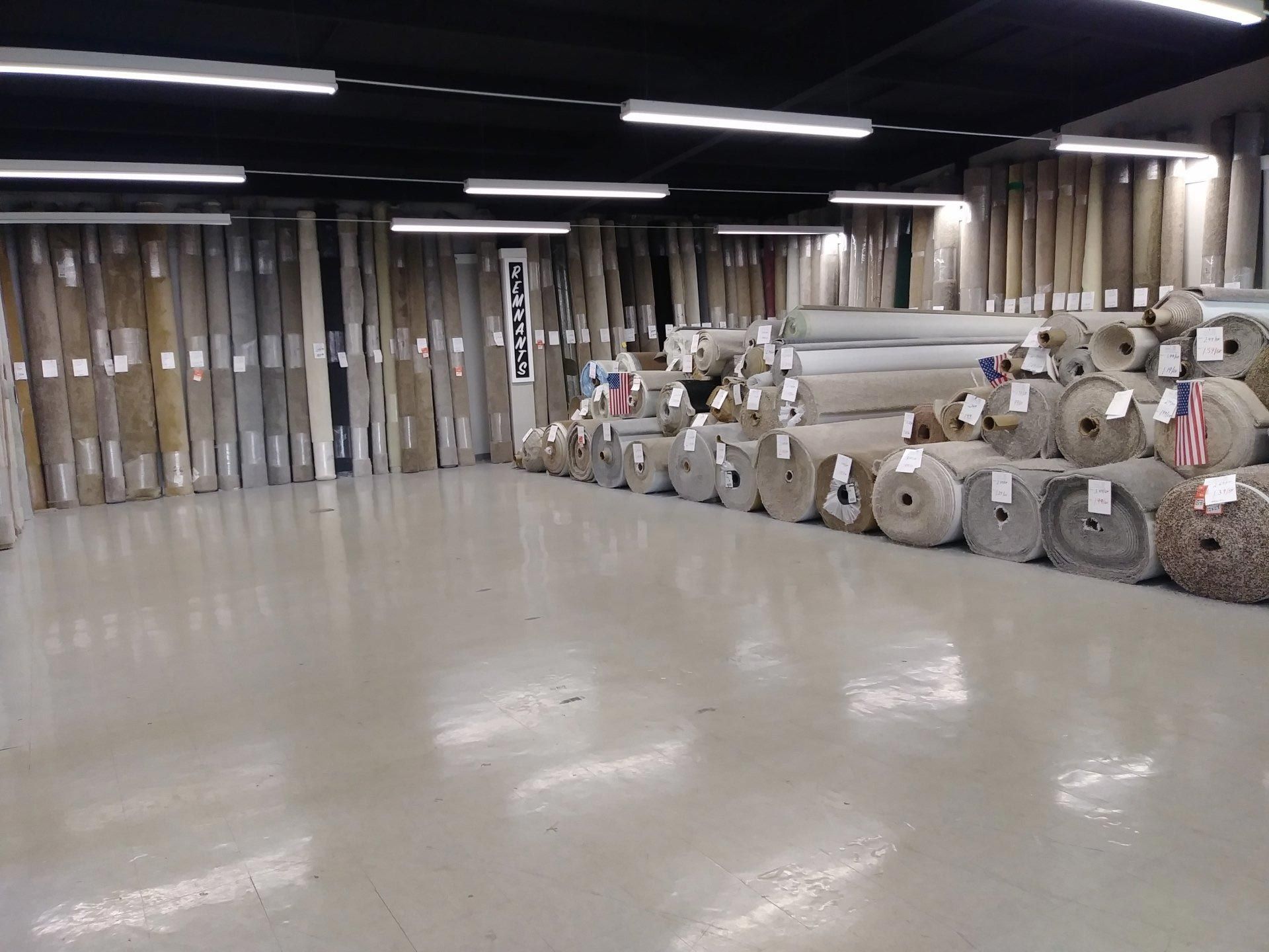 a large room filled with lots of rolls of carpet .