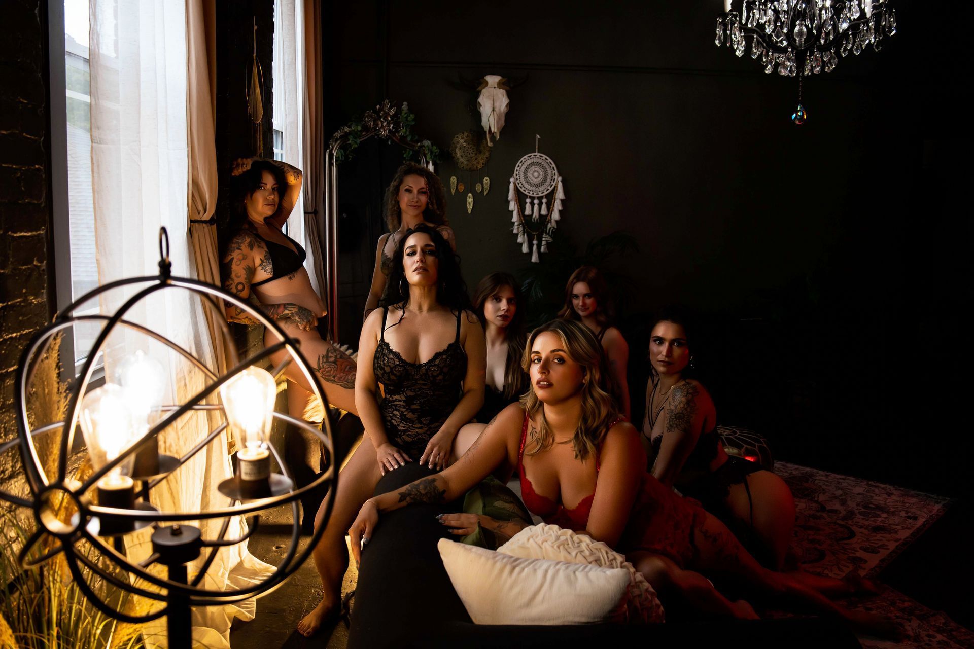 Five people seated in a dim, elegant lounge with a chandelier and warm lamp light