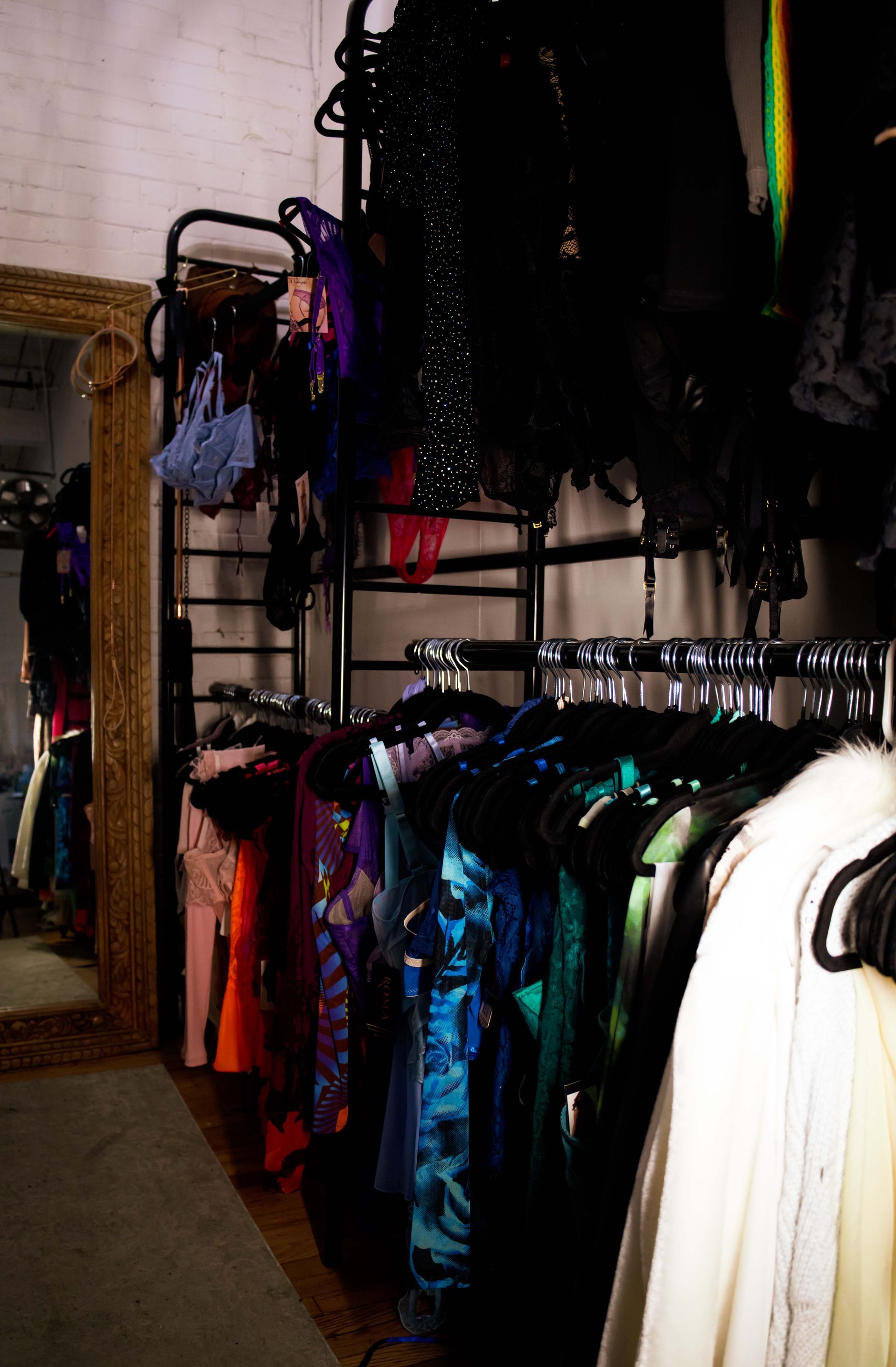 Clothing rack with colorful dresses and outfits hanging in a store or closet area