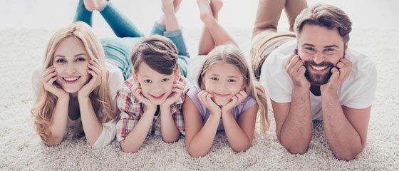 Happy family relaxing on carpet