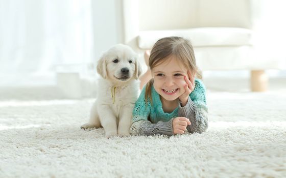 The child with the dog lying on carpet