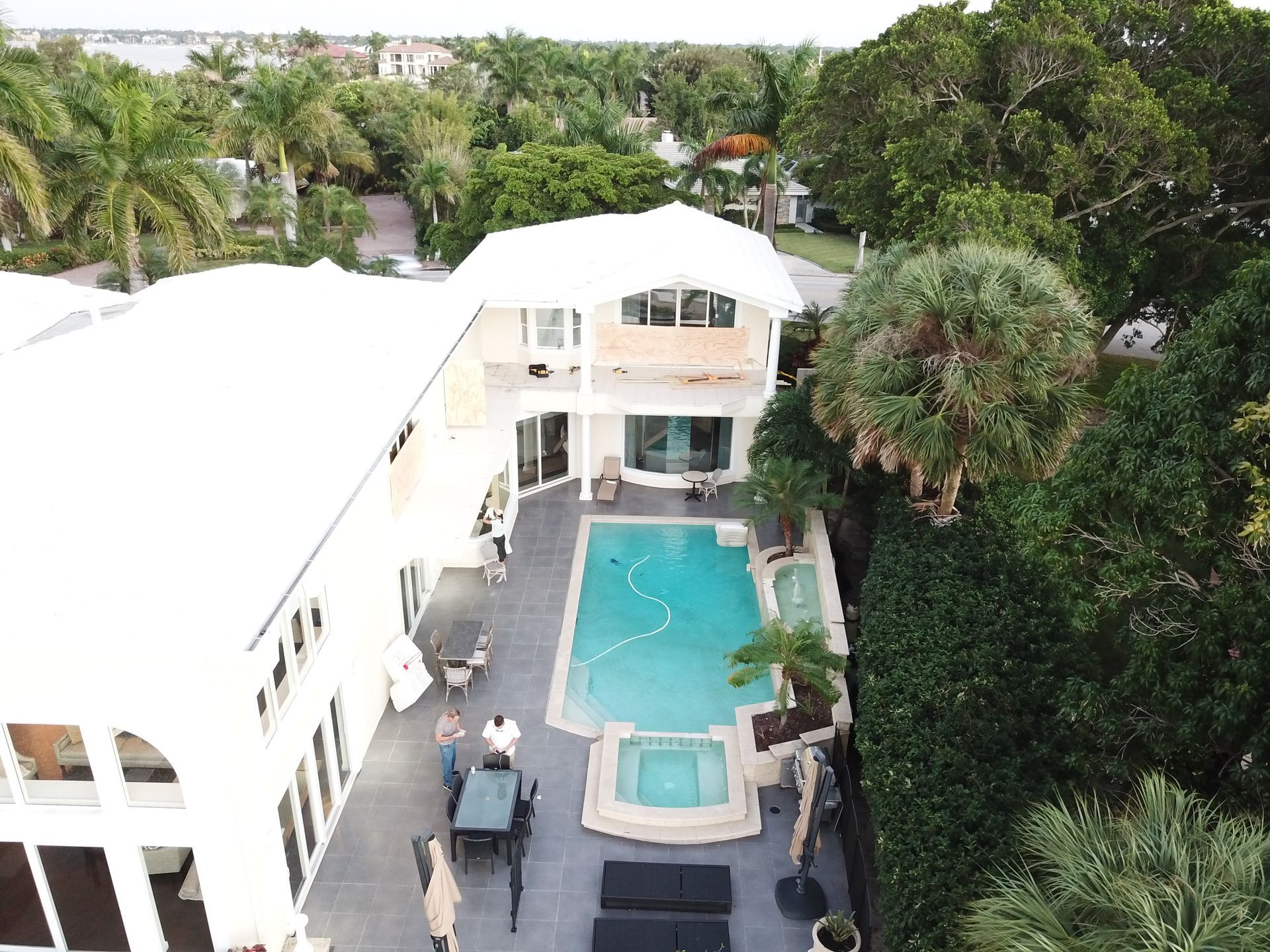 An aerial view of a house with a large swimming pool