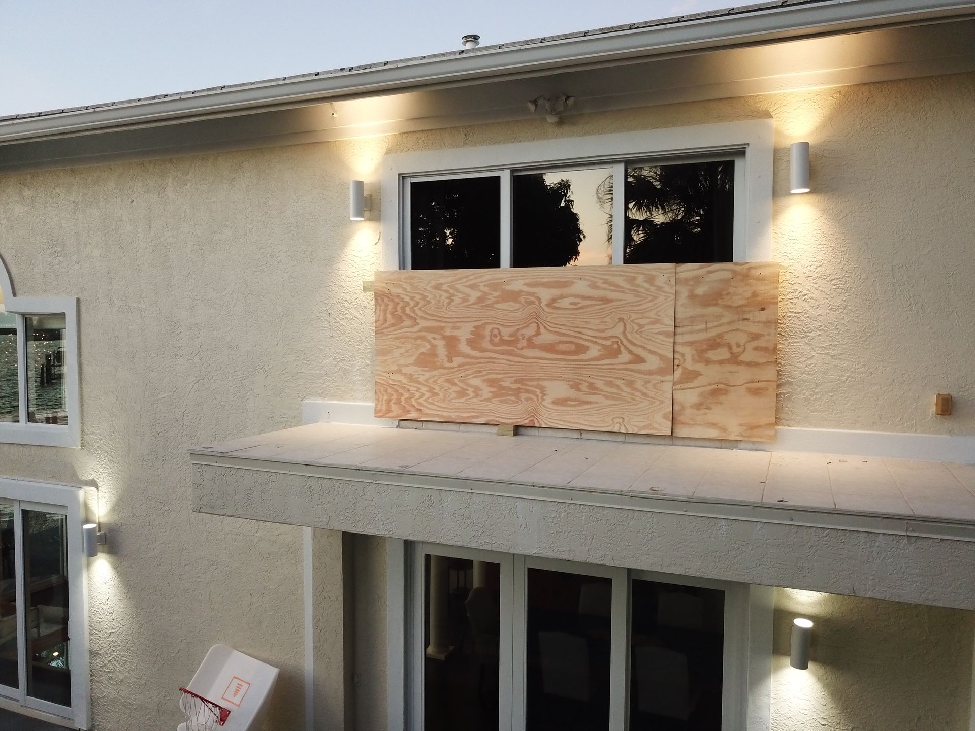 A house with a window boarded up with plywood