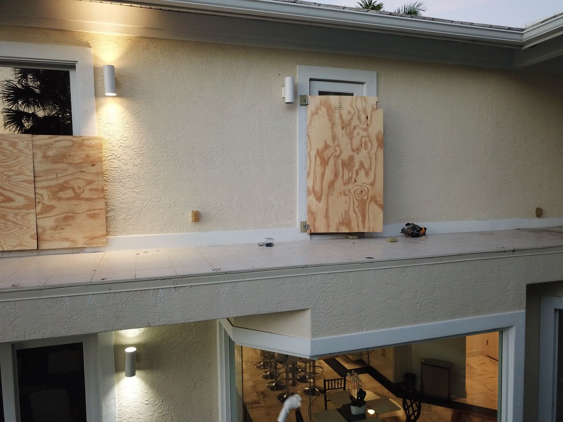A house with a window boarded up with plywood