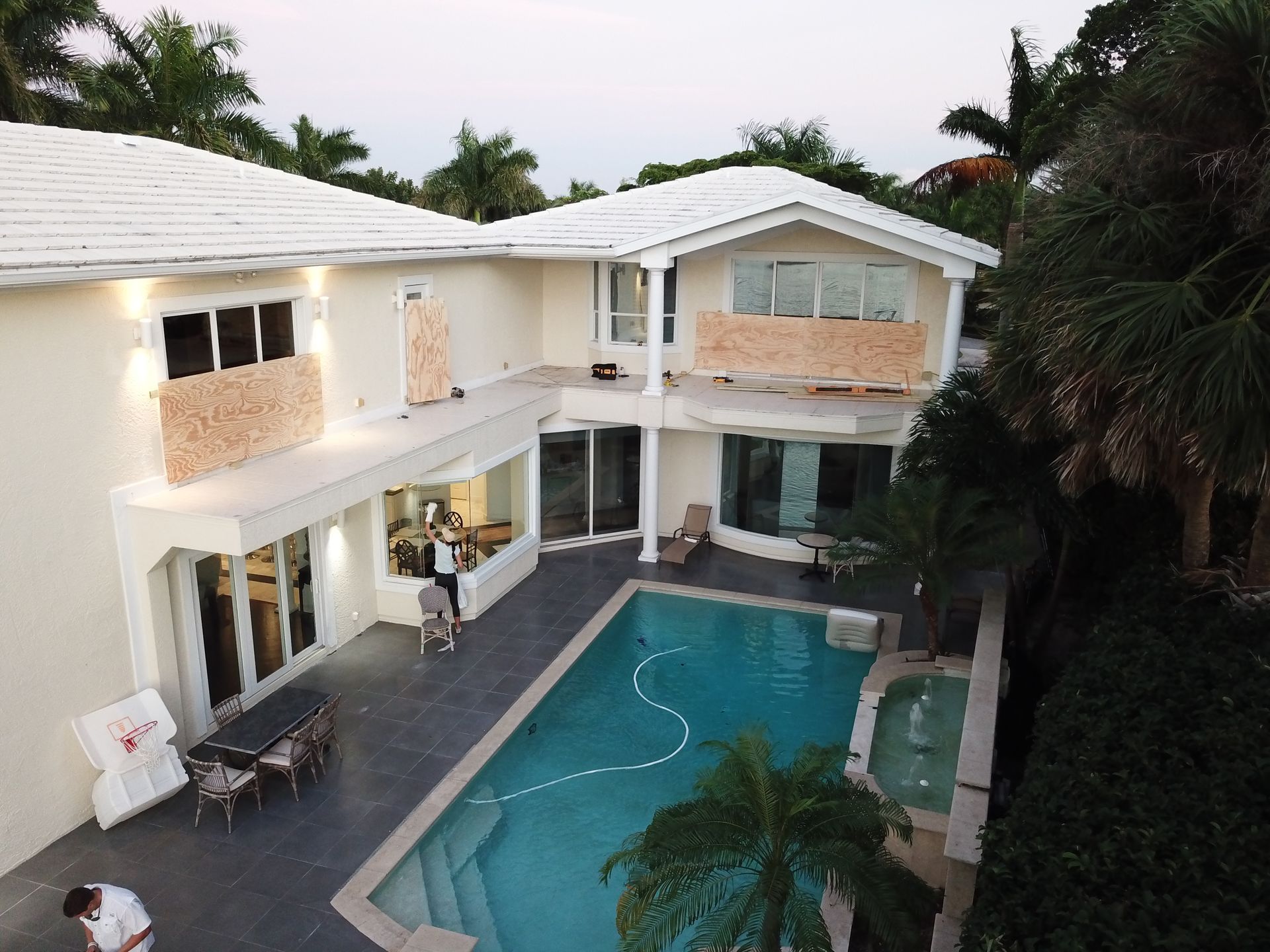 An aerial view of a house with a large swimming pool