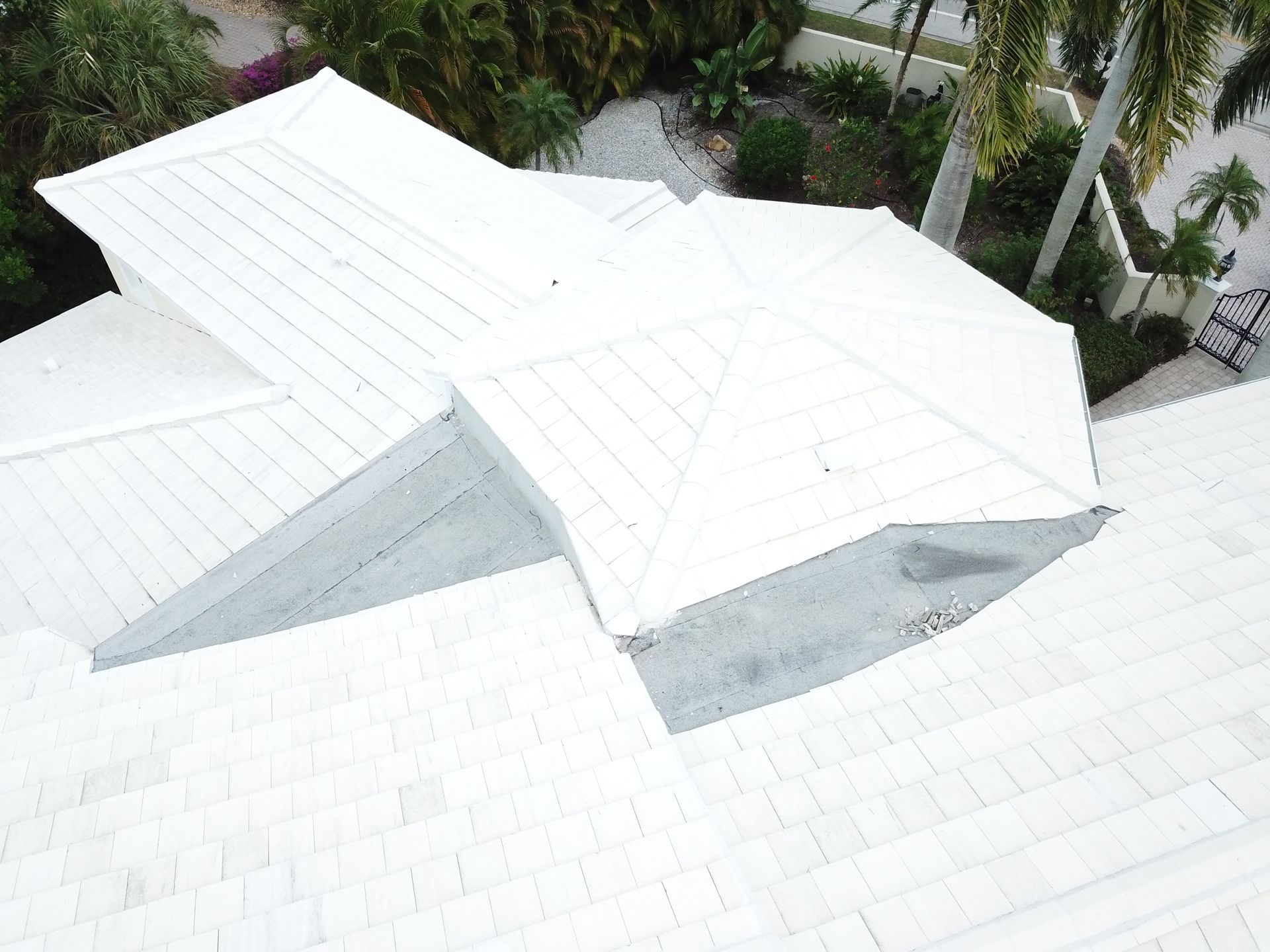 An aerial view of a white roof with a bird flying over it.