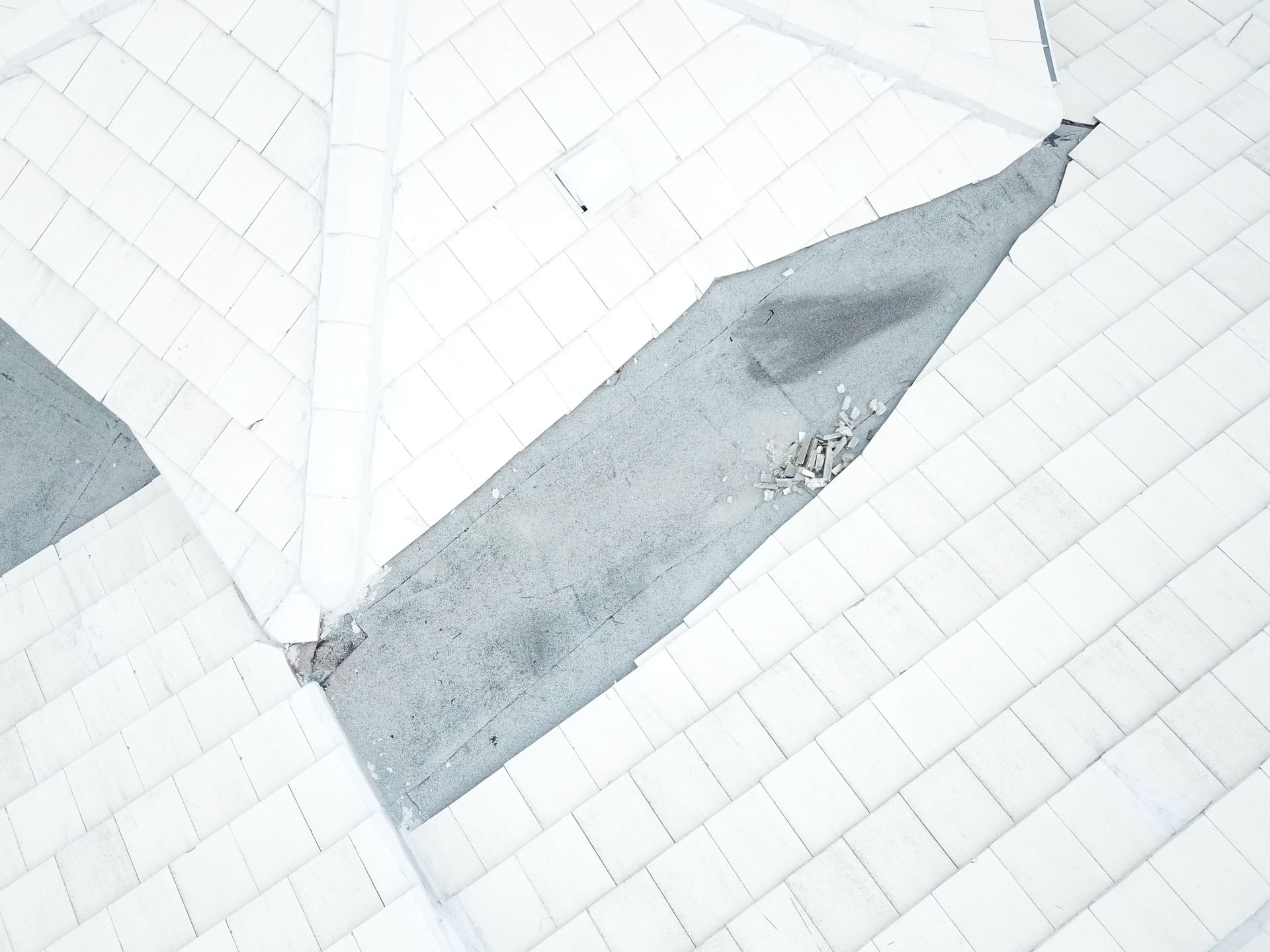 An aerial view of a white tiled floor with a diagonal line.