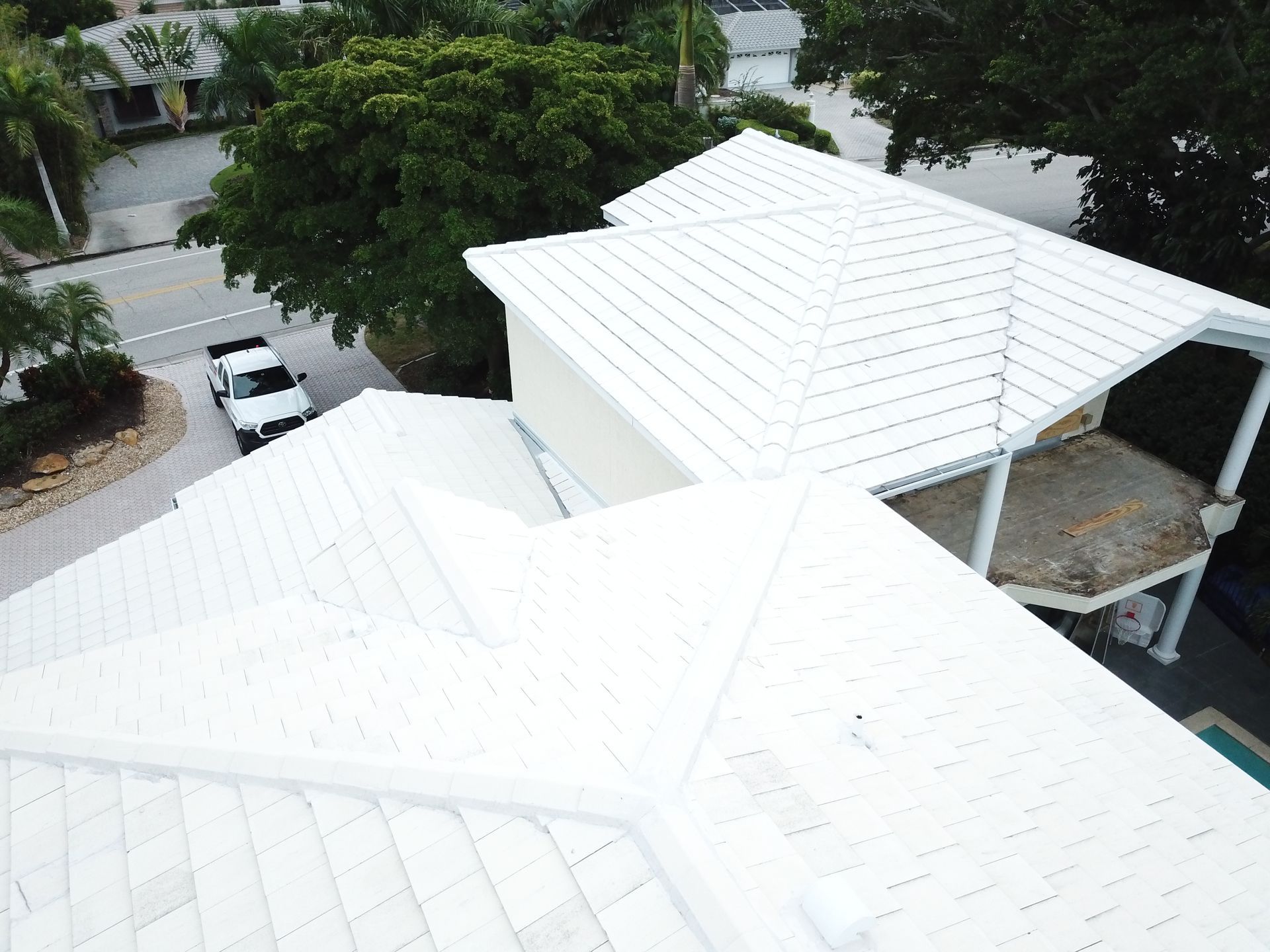 An aerial view of a white house with a white roof.