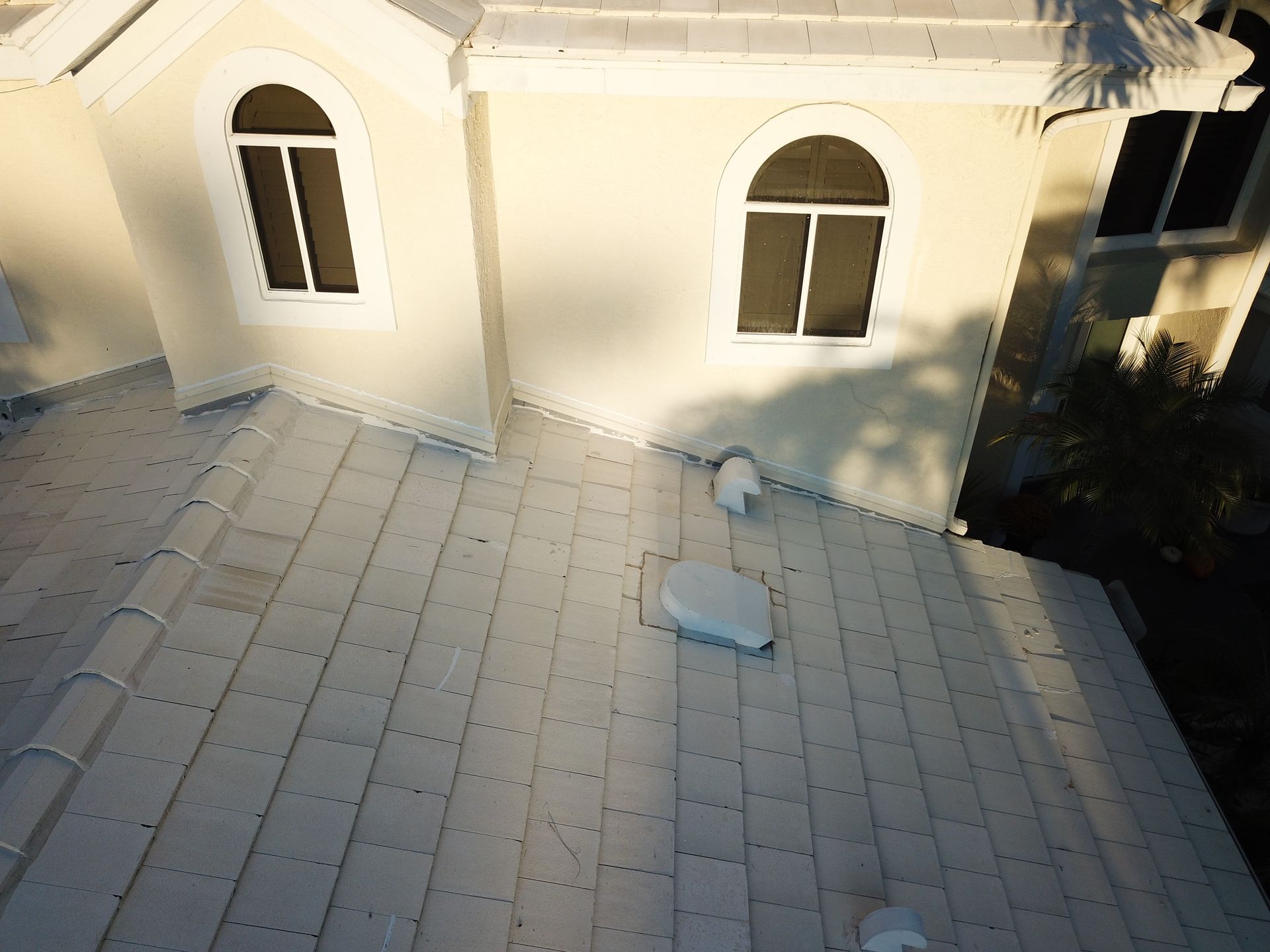 An aerial view of a white house with arched windows.