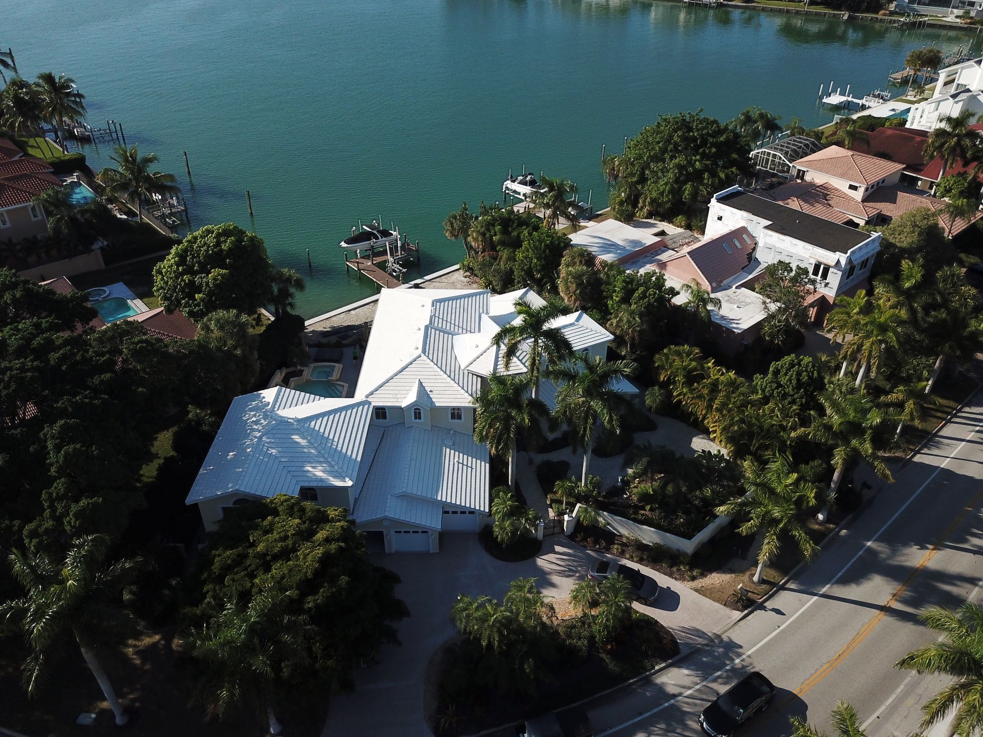 An aerial view of a house next to a body of water