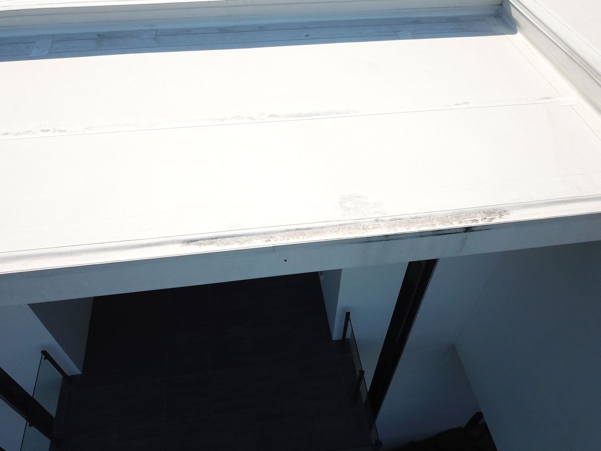 A white roof with a black door in the background