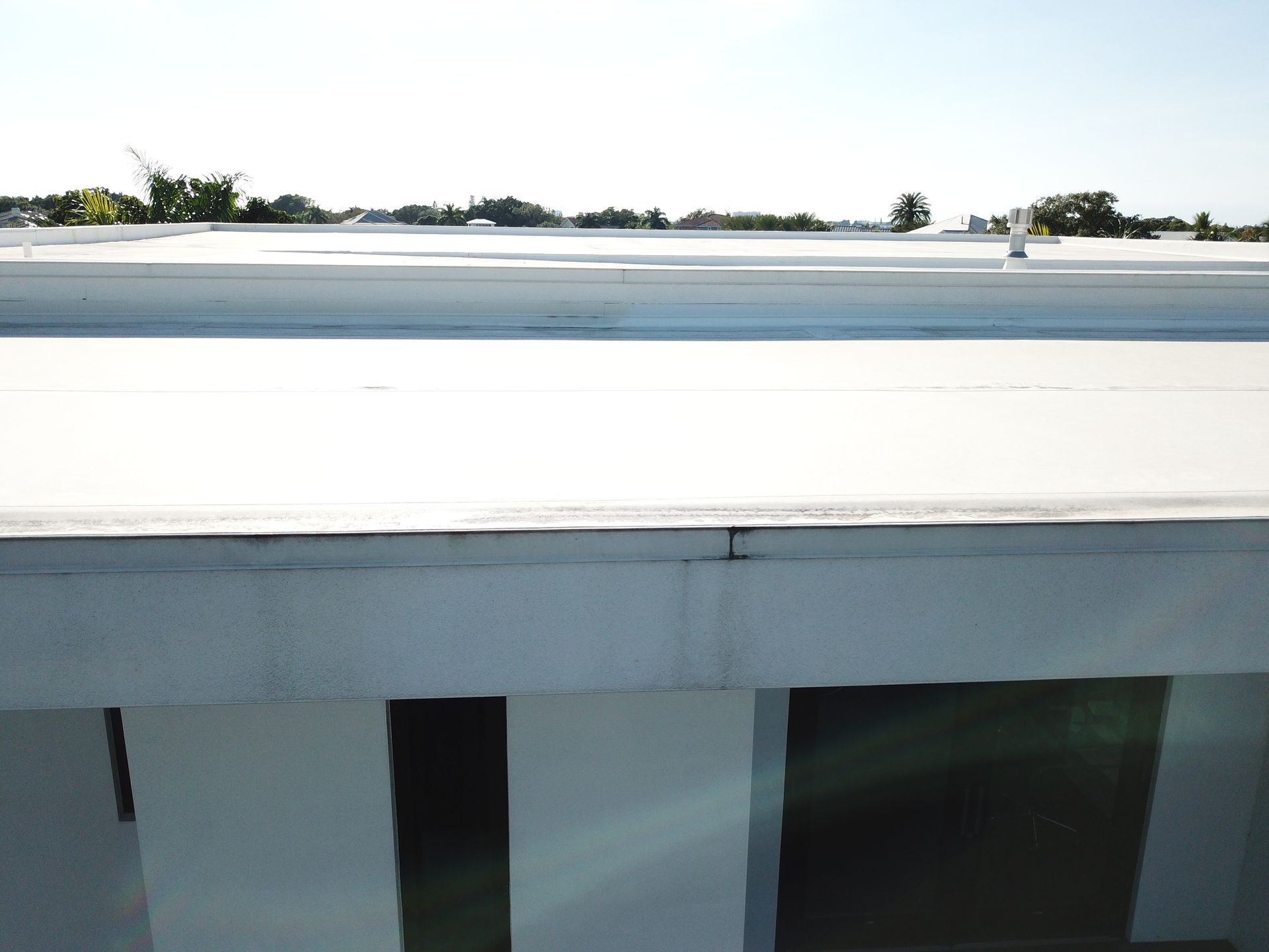 An aerial view of a building with a white roof