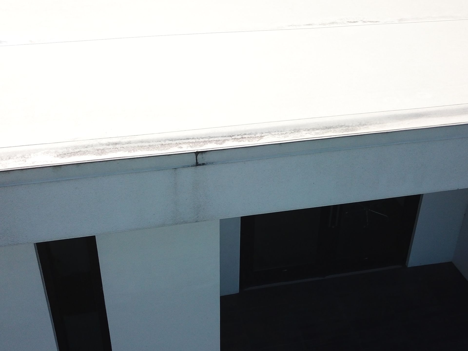 A white roof with a black door in the background