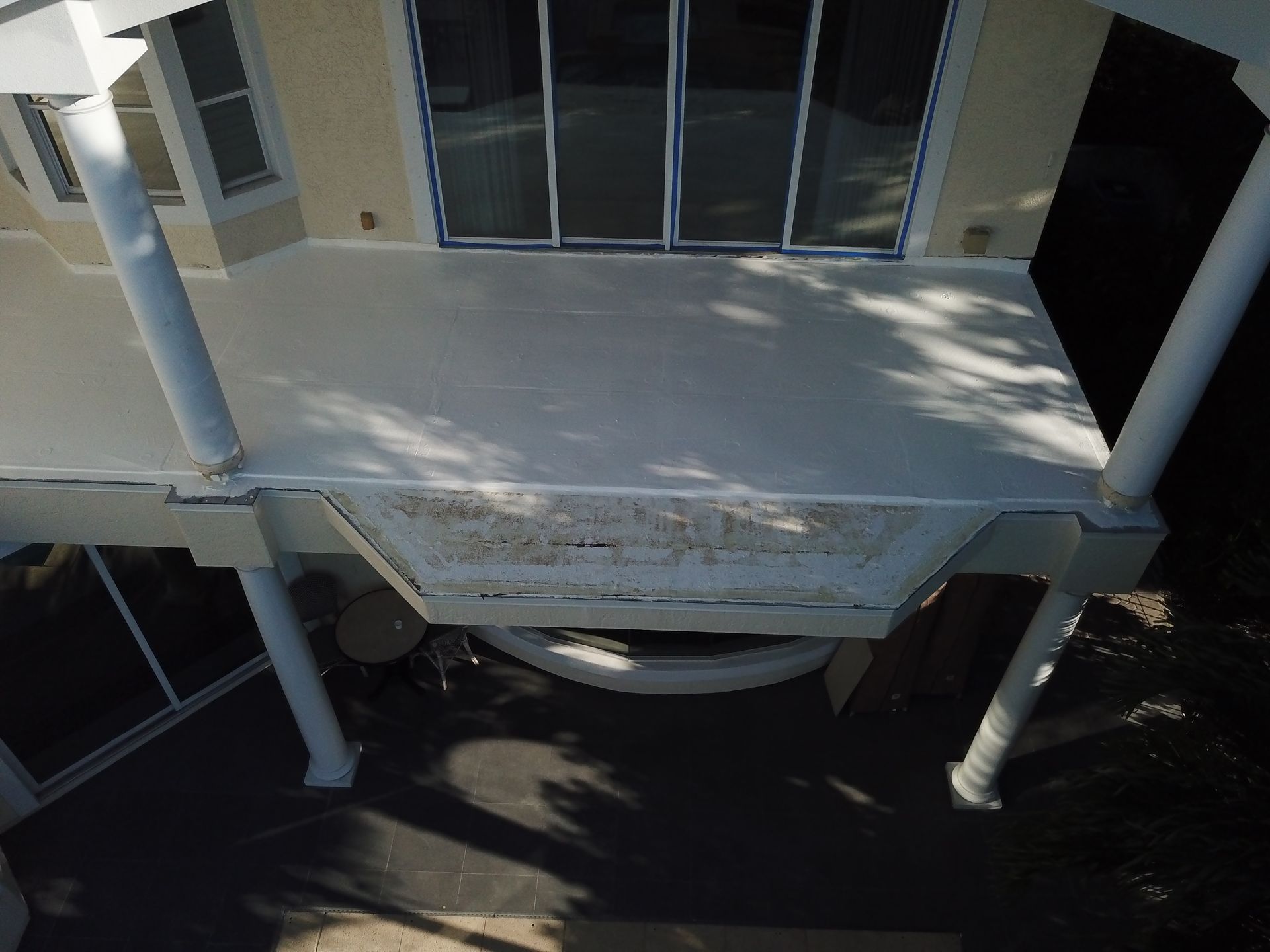 An aerial view of a house with a white roof
