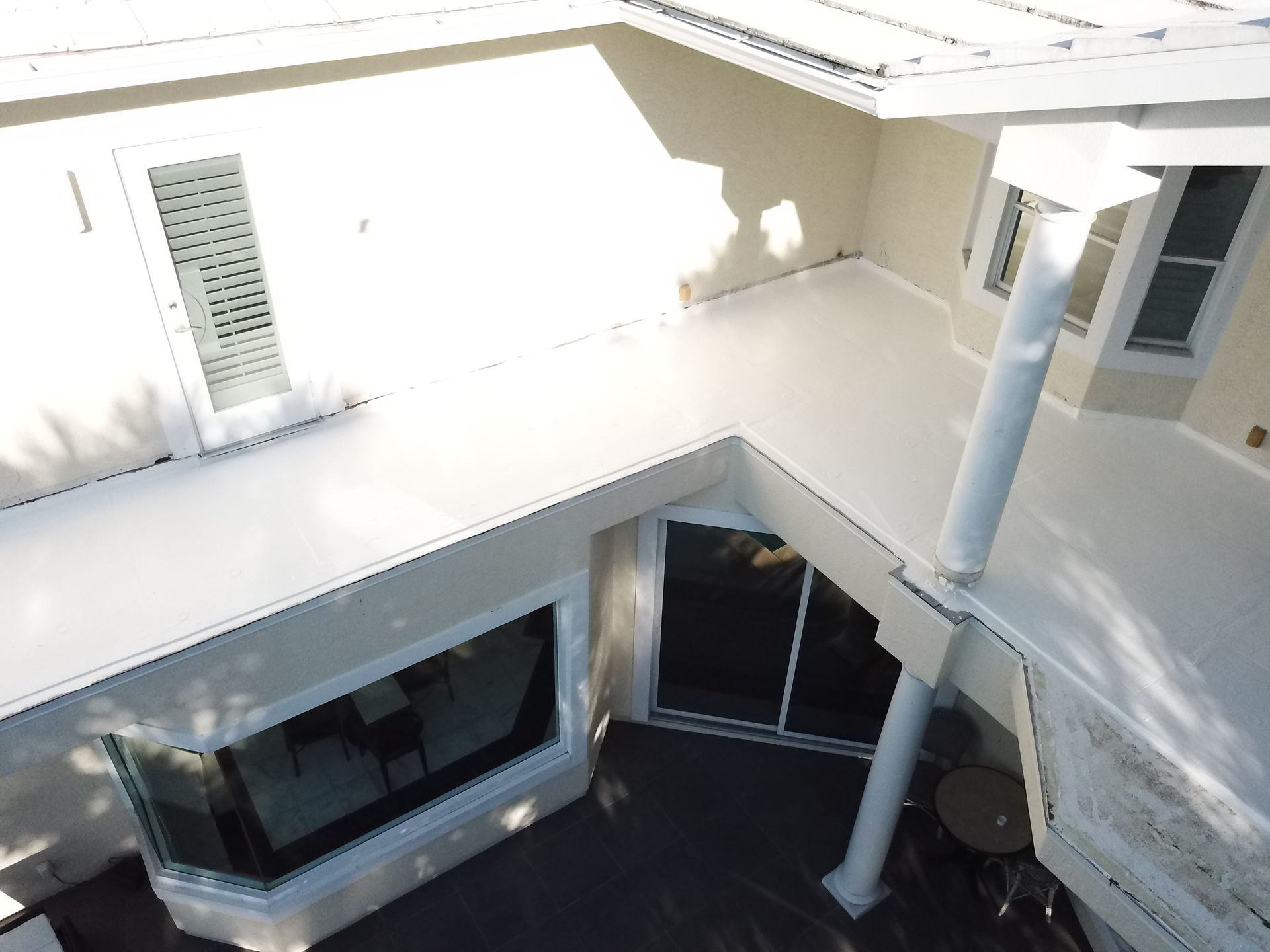 An aerial view of a house with a white roof