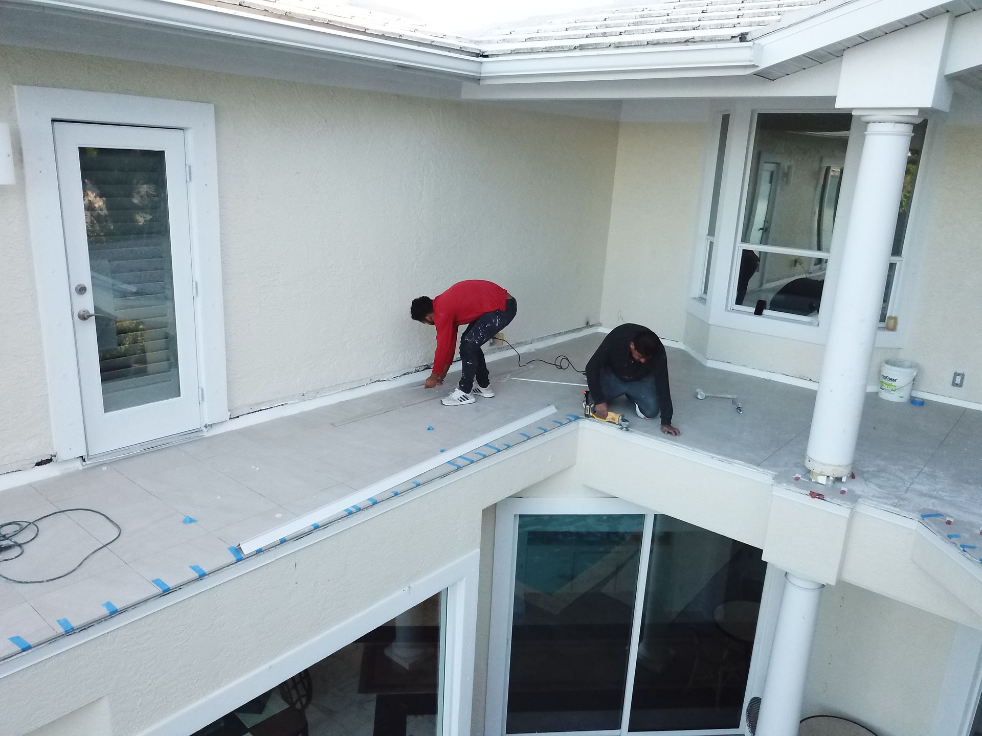 Two men are working on the roof of a house.