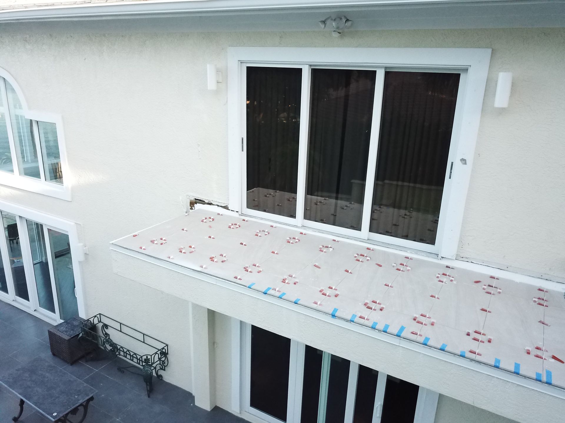 An aerial view of a house with a balcony and sliding glass doors.