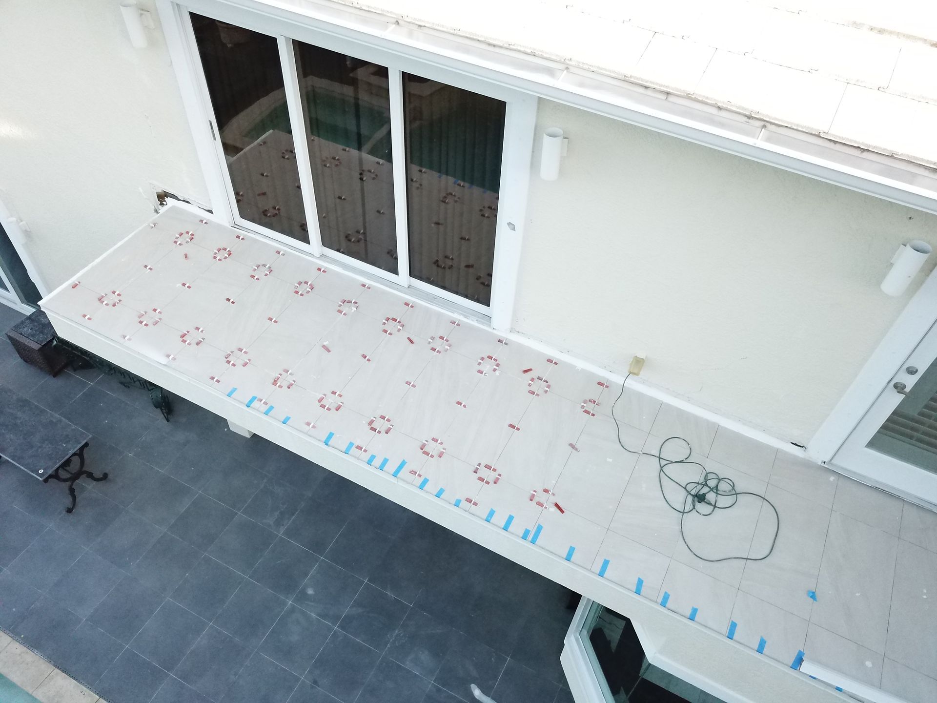 An aerial view of a house with a balcony and a sliding glass door.