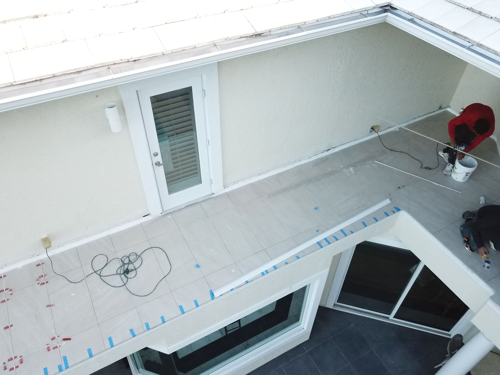 An aerial view of a person painting a house