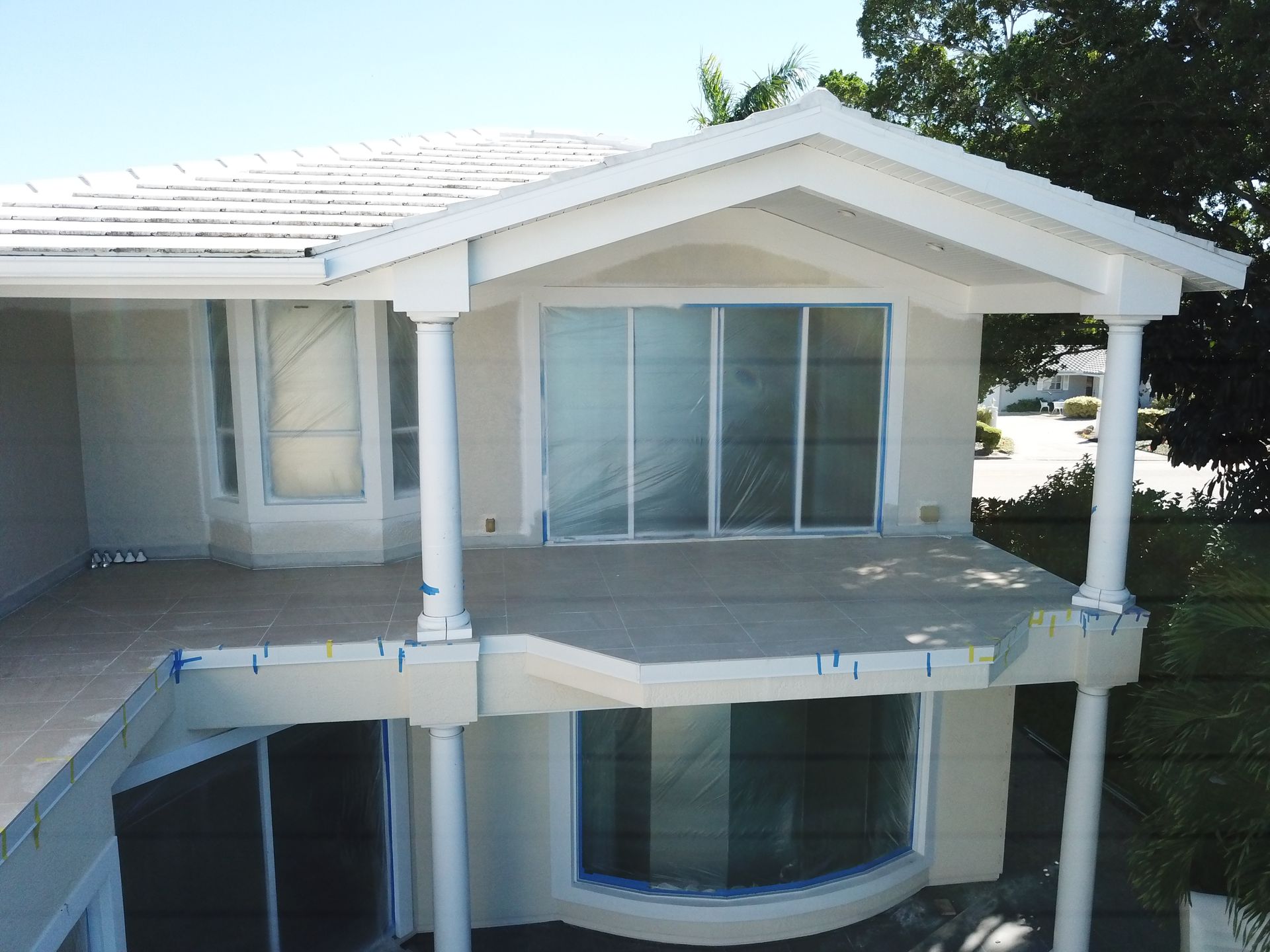An aerial view of a white house with a balcony