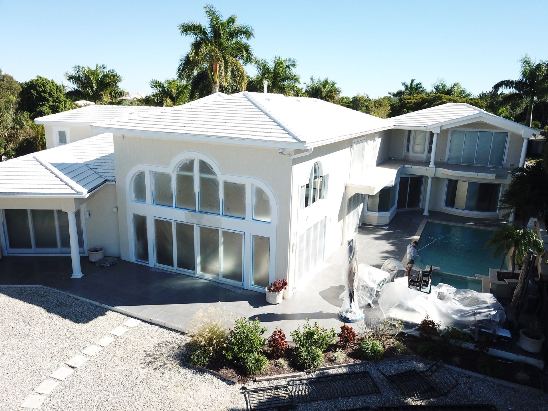 An aerial view of a large white house with a pool