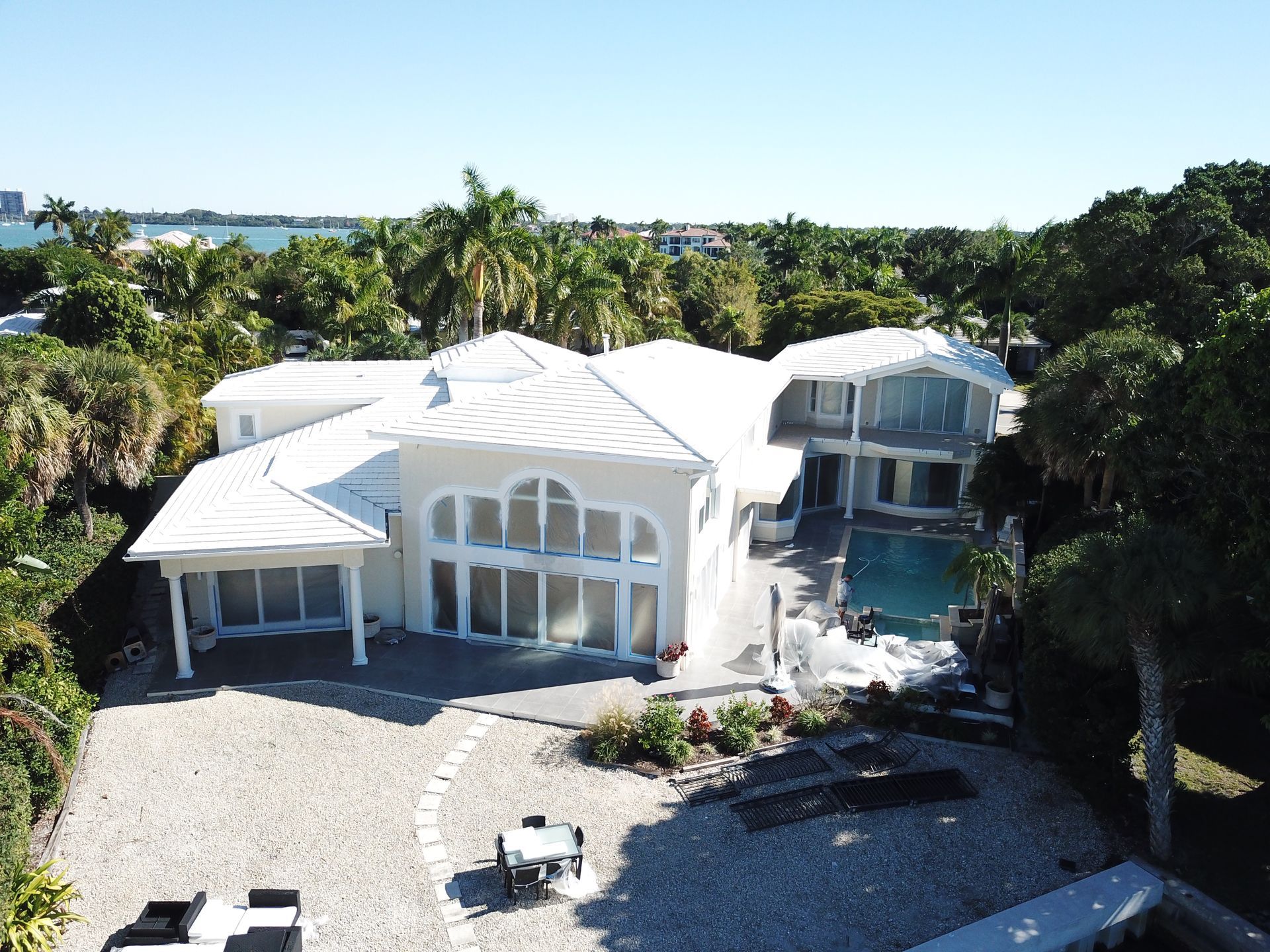 An aerial view of a large white house with a pool