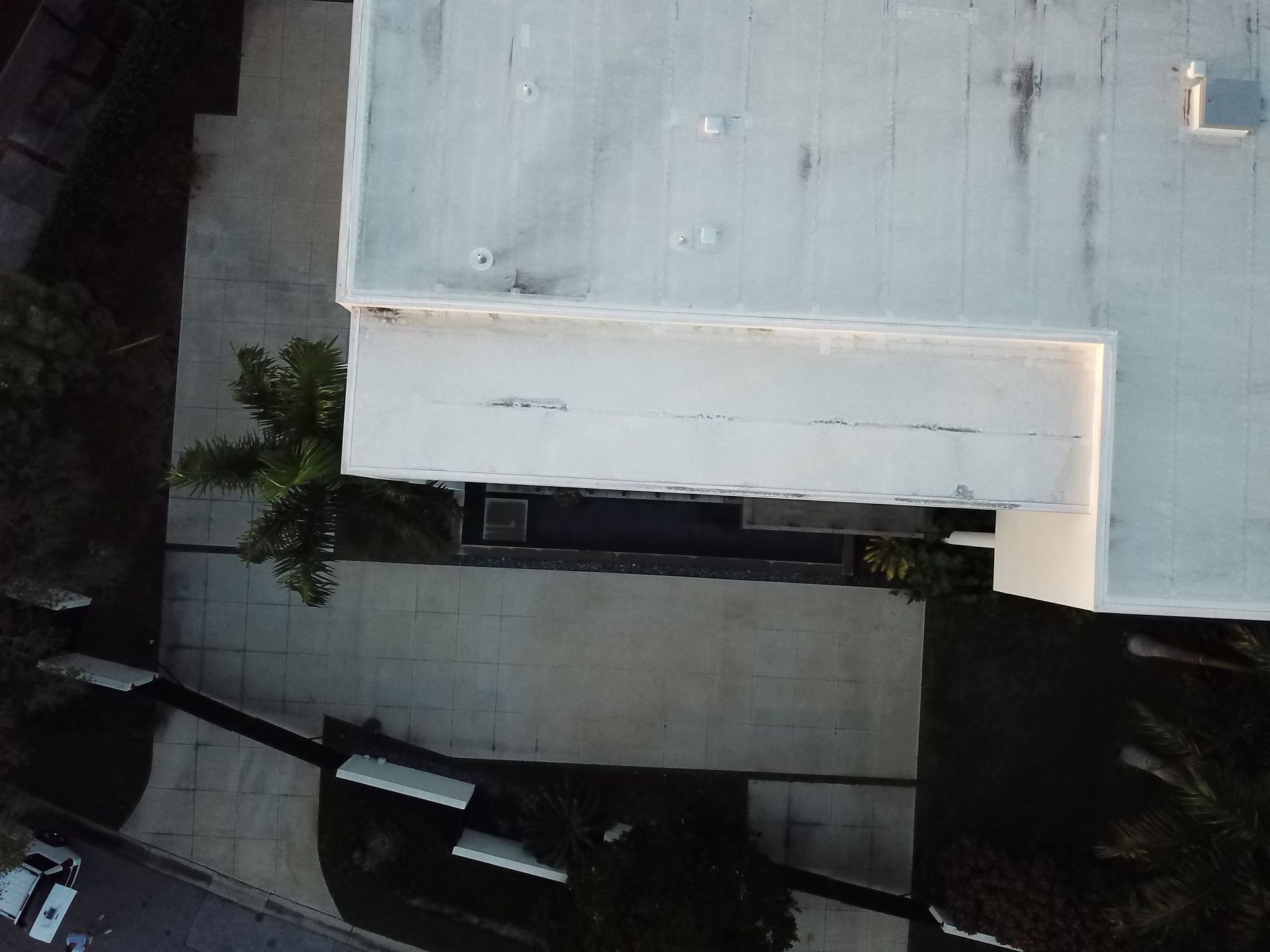 An aerial view of a building with a white roof
