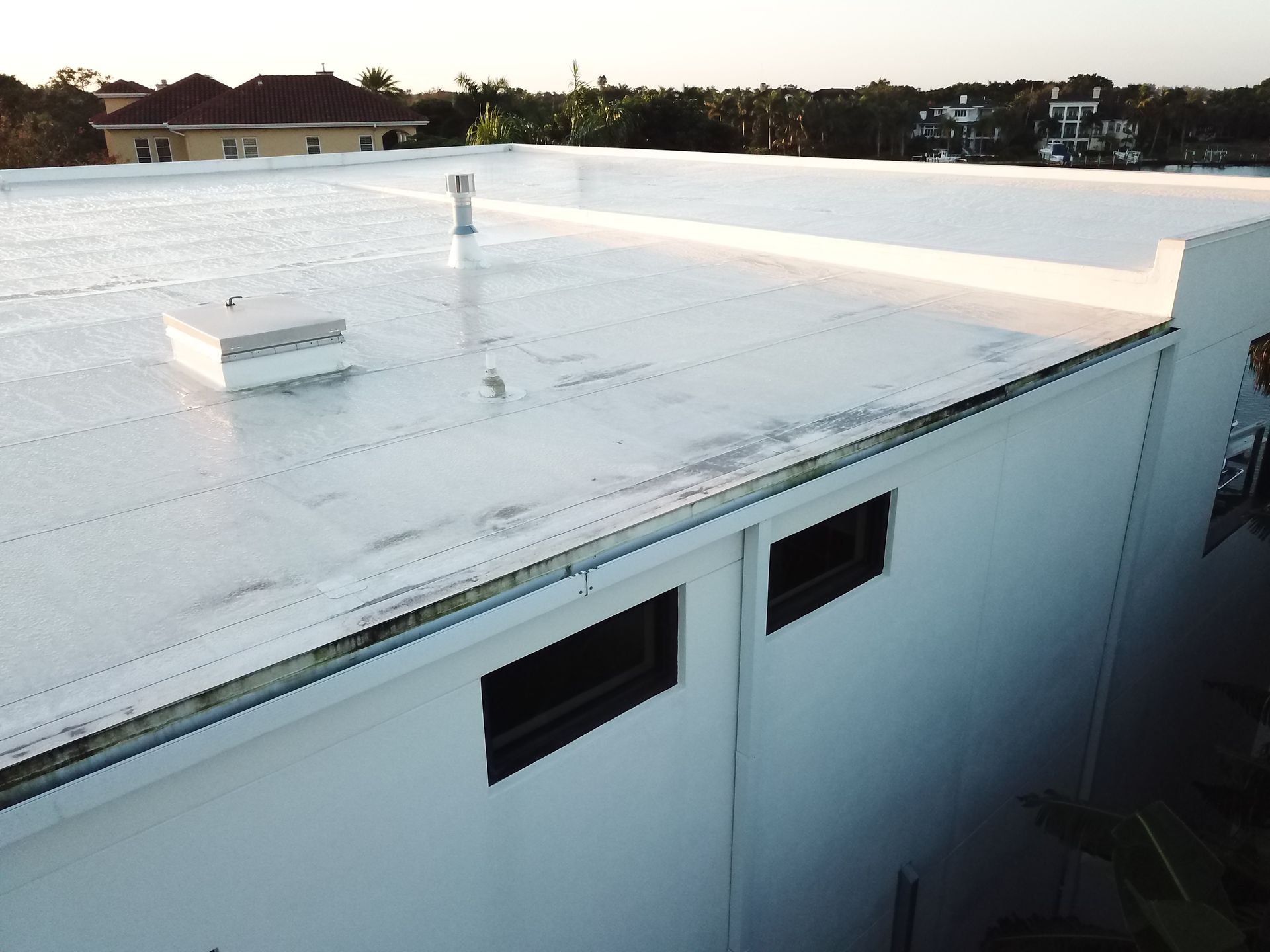 An aerial view of a white building with a white roof.