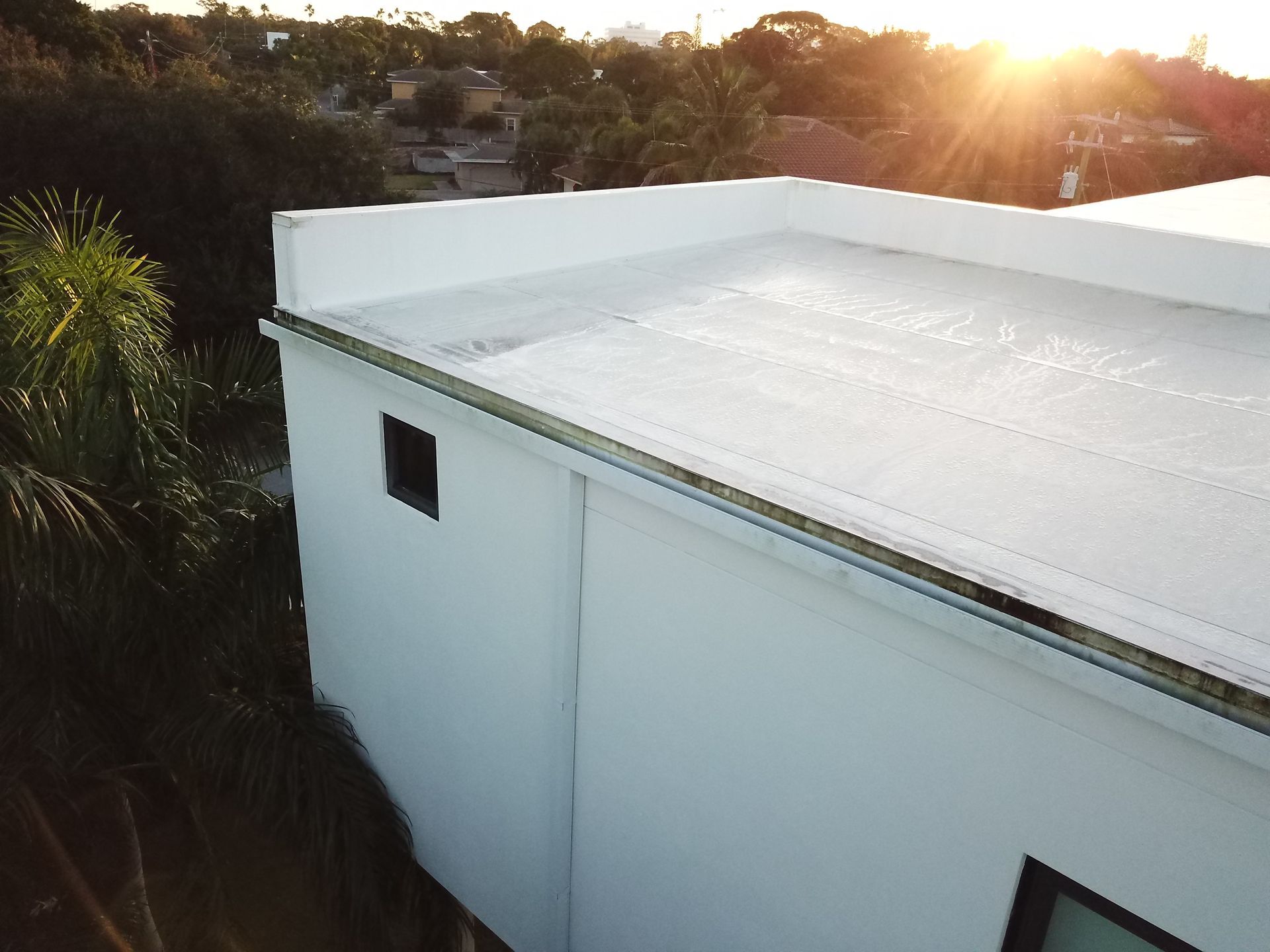 An aerial view of a white house with a white roof