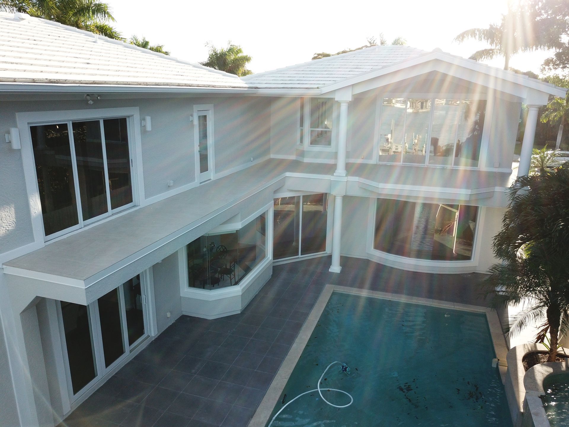 An aerial view of a large white house with a swimming pool.