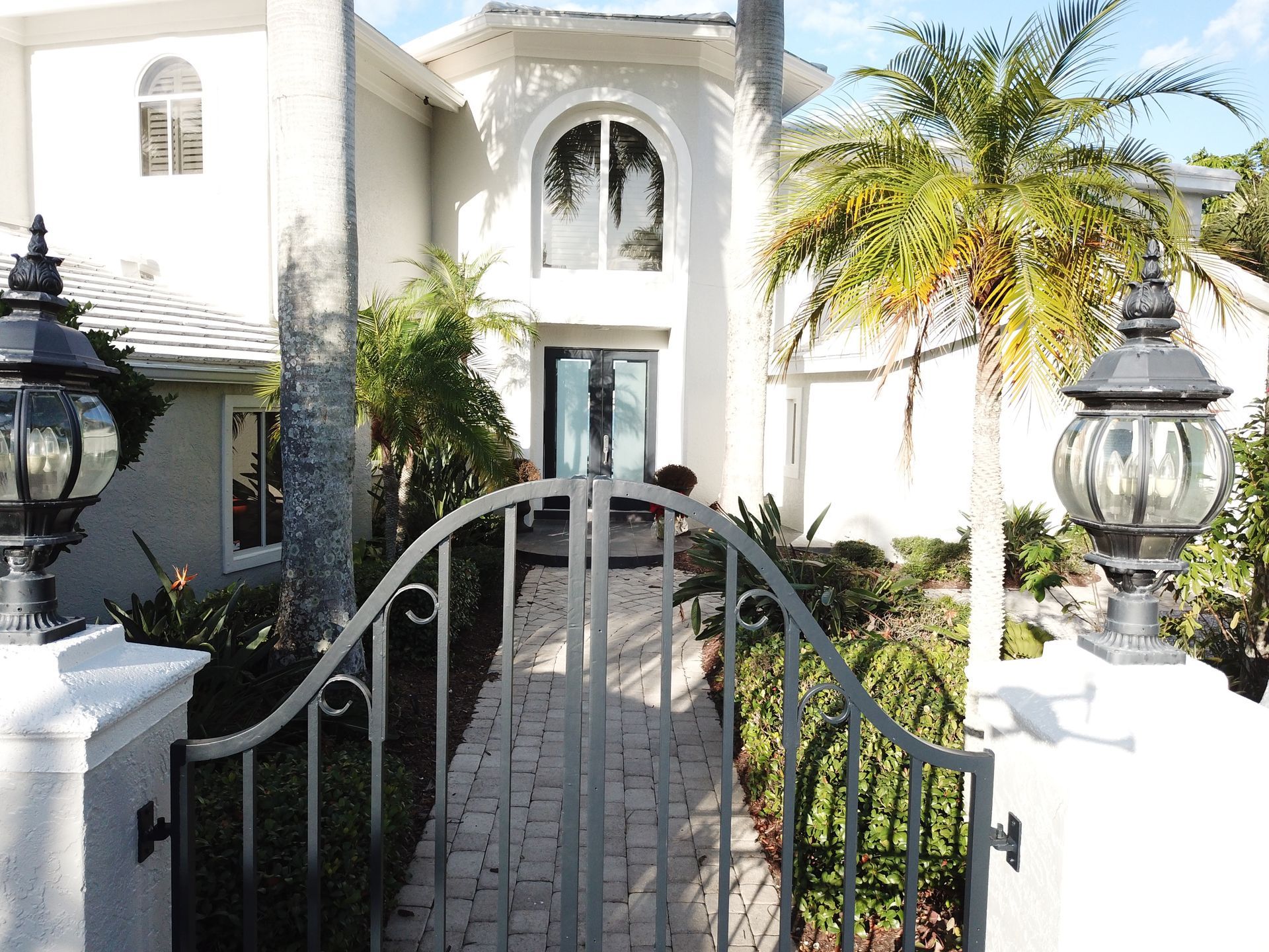 A white house with a black gate leading to it