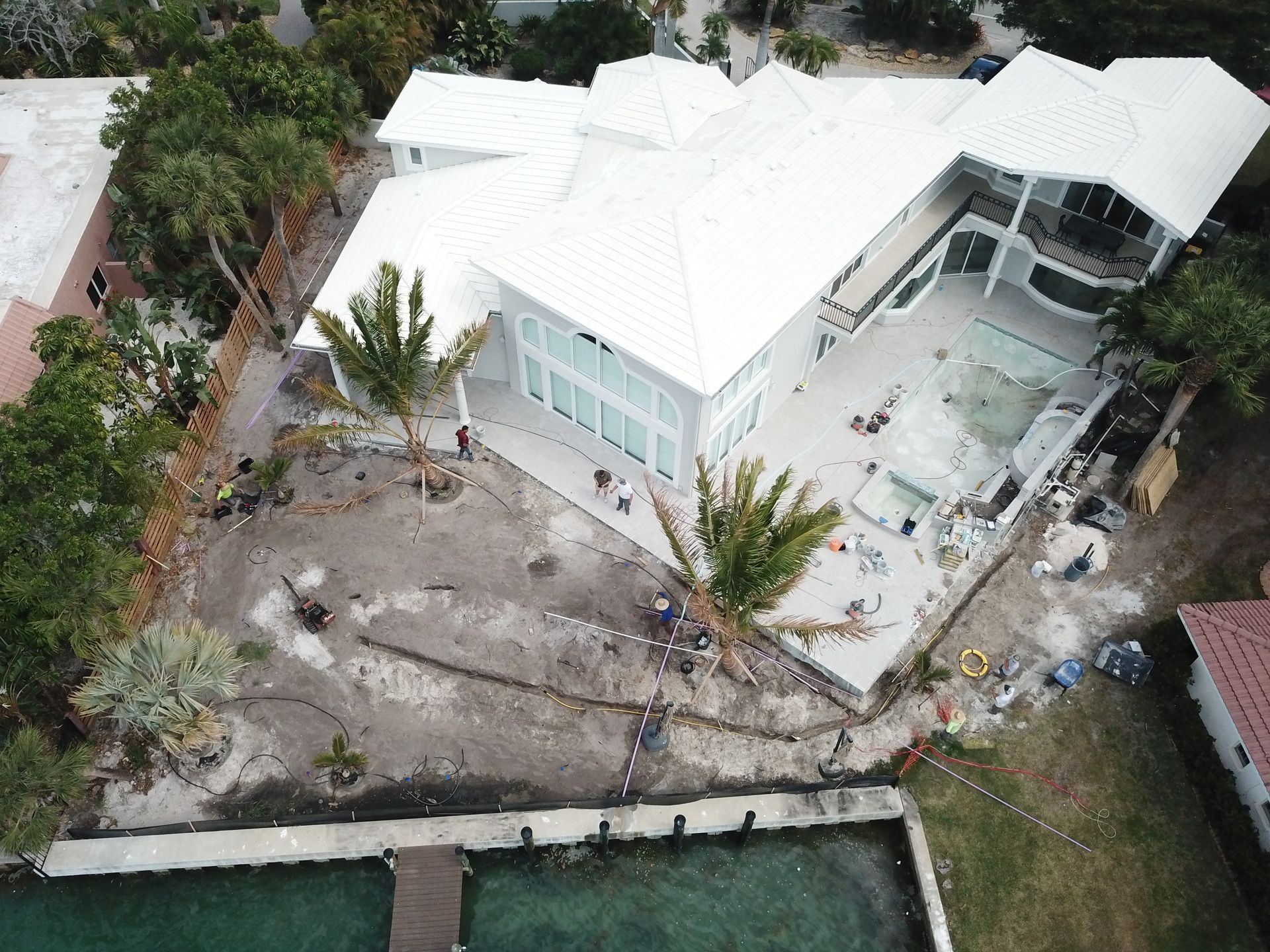 An aerial view of a large white house with a pool