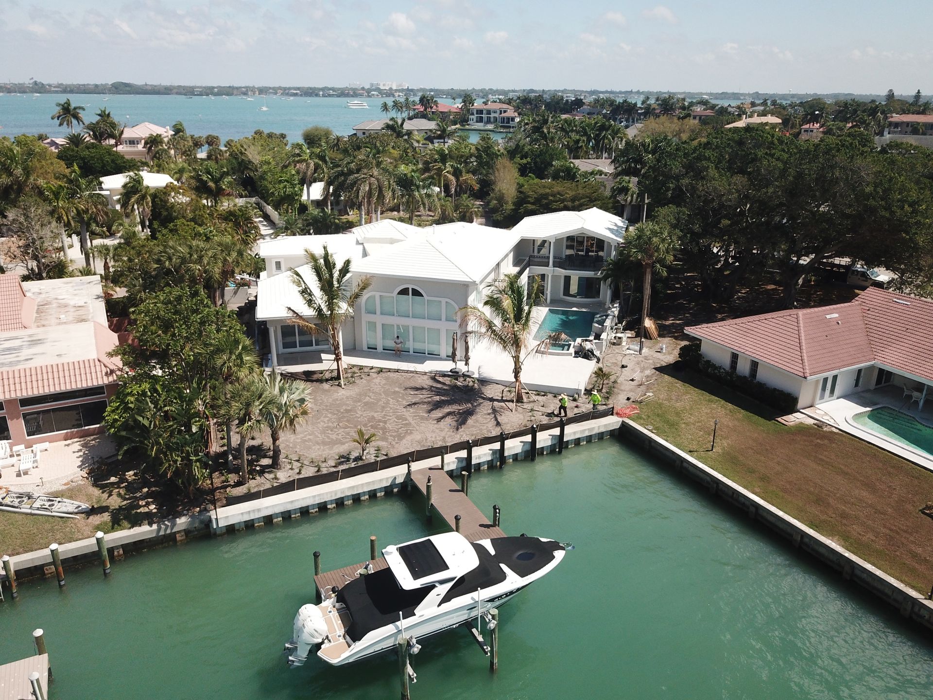 An aerial view of a large house with a boat docked in front of it