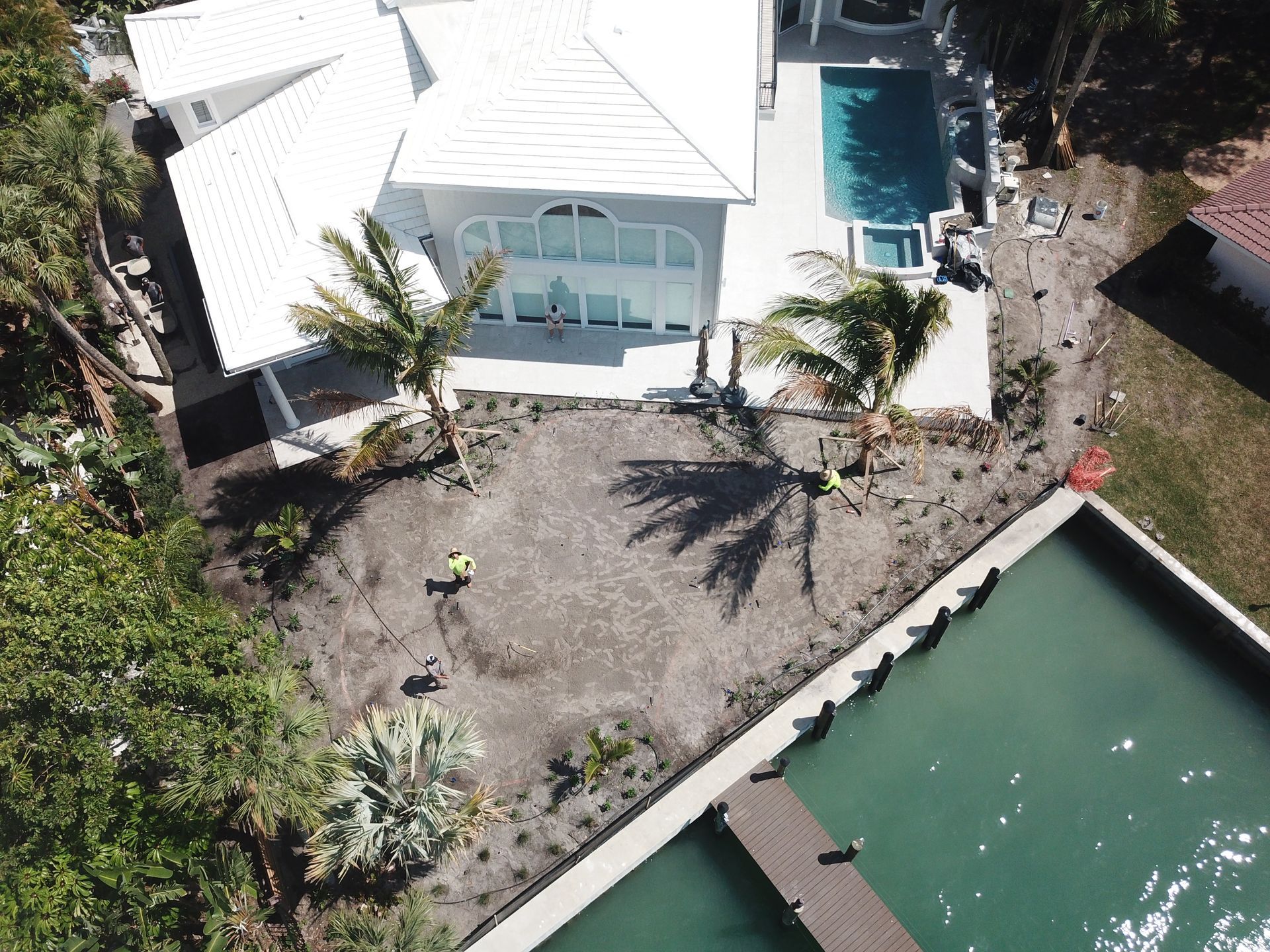 An aerial view of a house with a pool and a dock