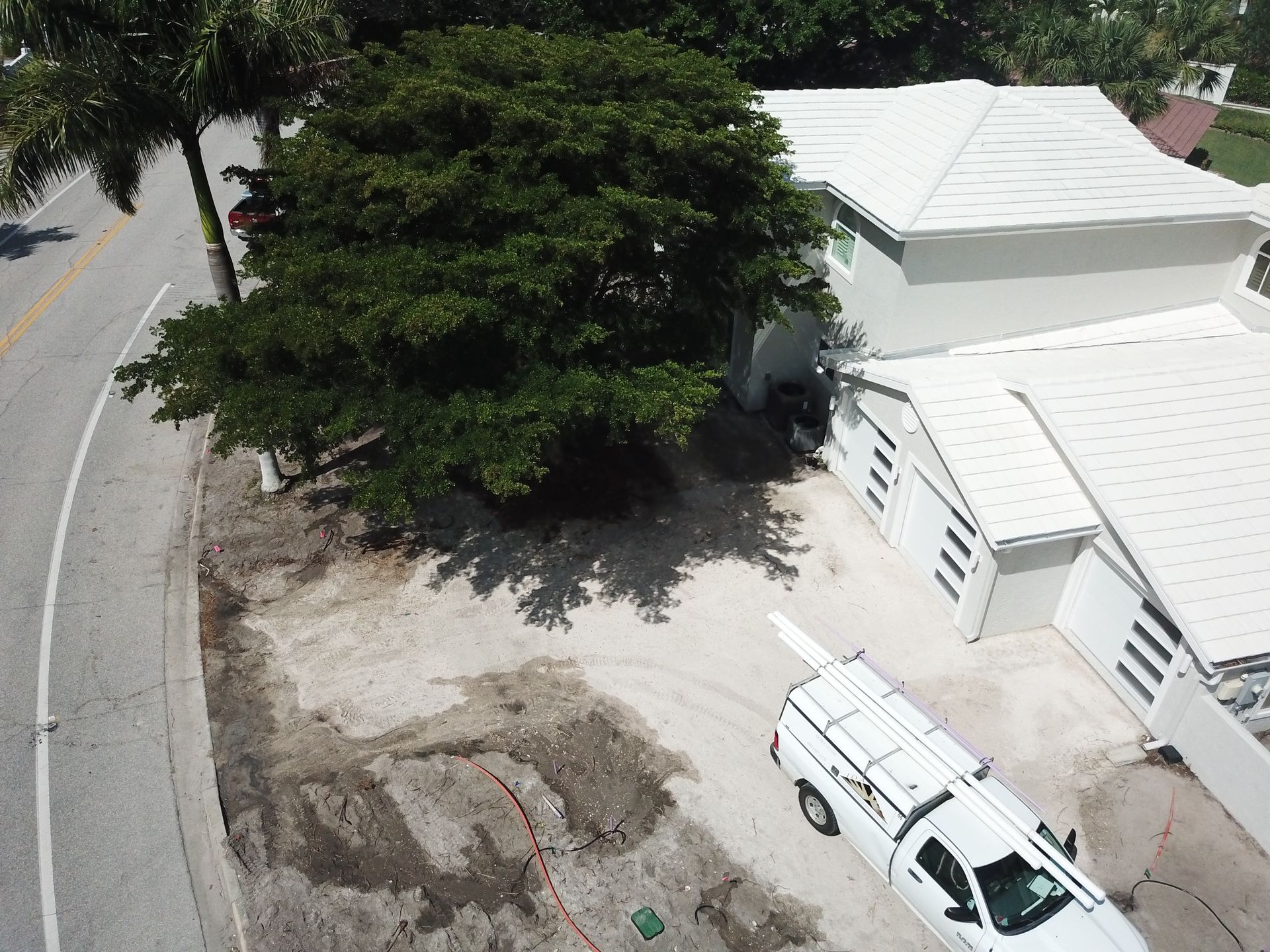 An aerial view of a white truck parked in front of a house