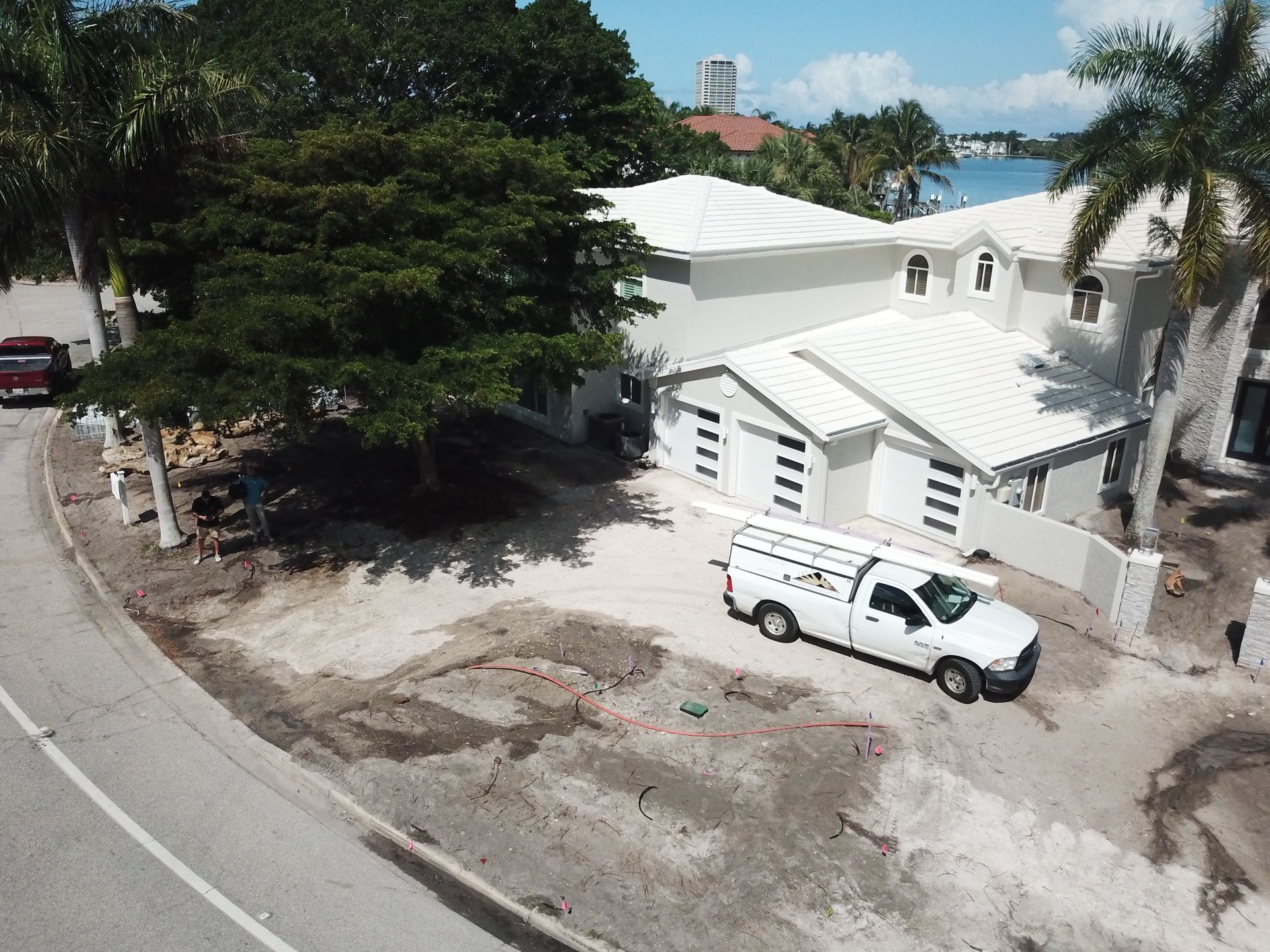 An aerial view of a white truck parked in front of a house