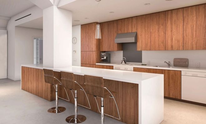 Modern kitchen with wooden cabinets, white island and bar stools, and stainless steel appliances.