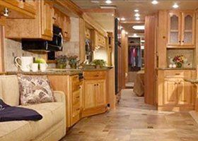 Wood-paneled kitchen and hallway in a warm, cozy RV interior.