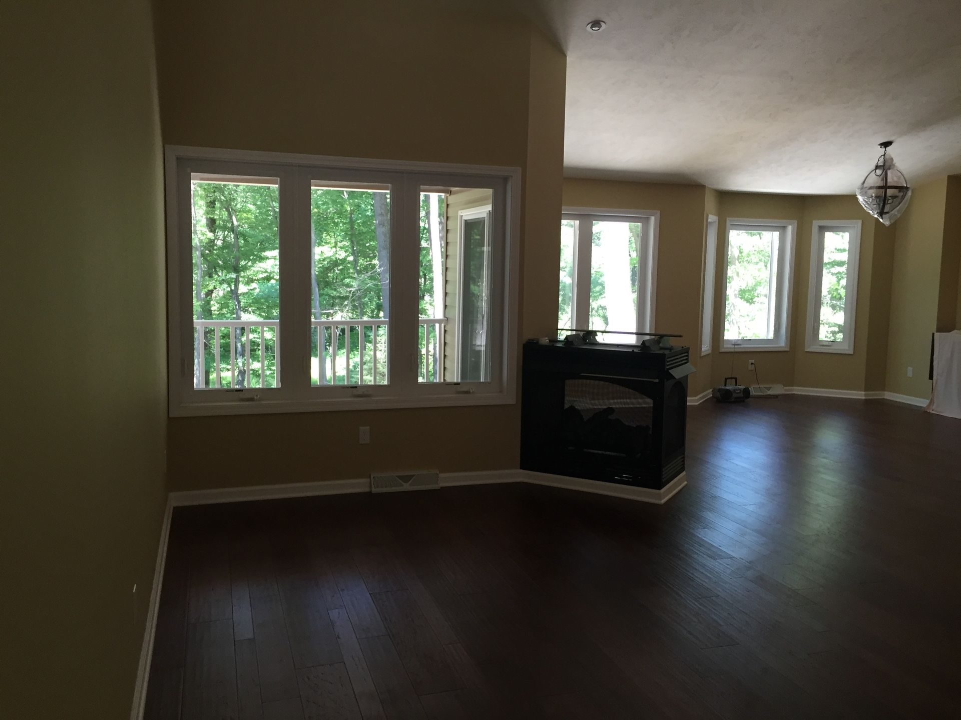 An empty living room with hardwood floors and a fireplace