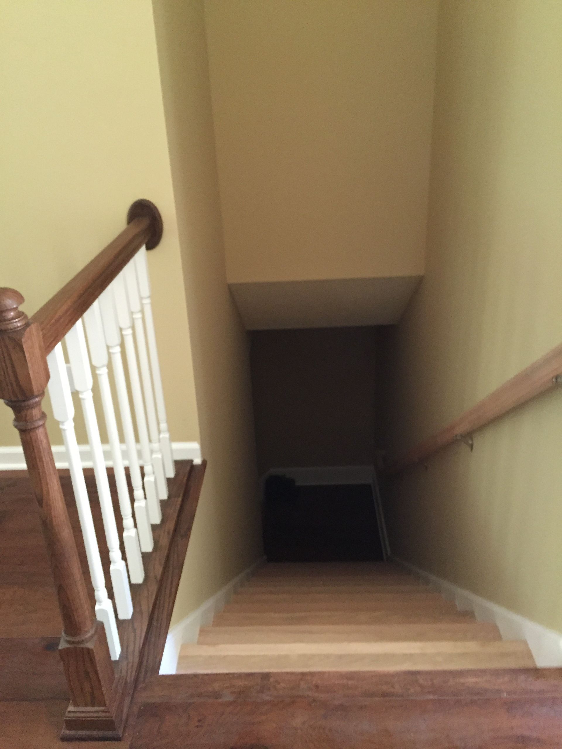 A wooden staircase with a white railing going up to the second floor
